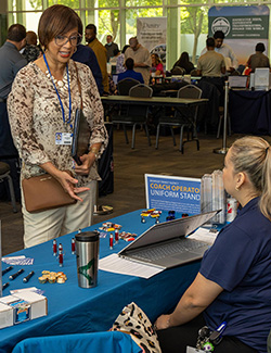 Woman inquiring about BERC services at an informational booth.