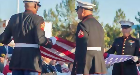Servicemen folding an American flag.