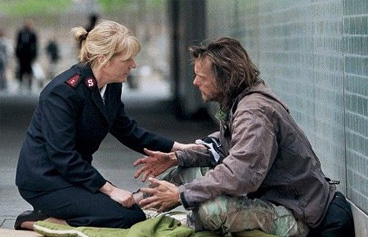Woman helping a homeless man.